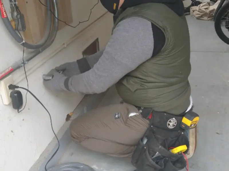Electrician performing outlet wiring in a Mills River garage